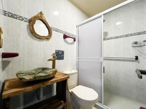y baño con lavabo, aseo y ducha. en Casa Emmanuel, en Salento