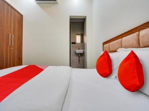 a bedroom with a large bed with red pillows at Hotel RS in Nagpur