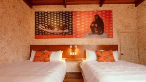 a bedroom with two beds and a painting on the wall at Macarena Hostel in Flores