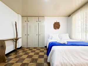 a bedroom with two beds with blue sheets at Casa Emmanuel in Salento