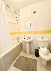 a bathroom with a sink and a toilet and a bath tub at Luxury Studio Kensington London - 24 7 Security in London