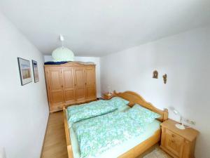 ObergünzburgにあるGemütliche Wohnung nahe Kempten (Obergünzburg)の小さなベッドルーム(ベッド1台、木製キャビネット付)
