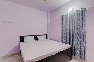 niewielka sypialnia z łóżkiem i zasłoną w obiekcie Gracious Guest House w mieście Lucknow