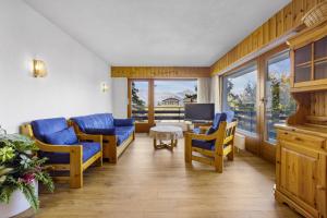a living room with blue chairs and a television at Christiania I F2 - 4 pers - pres des pistes in Nendaz