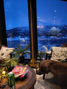 uma sala de estar com uma mesa e uma grande janela em Arctic Sealodge Malangen cabin 4 Sæterbergan 