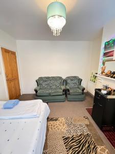a bedroom with a bed and two chairs and a chandelier at Big Private Room In Town Centre in Eastleigh