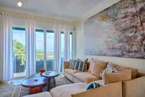 a living room with a couch and a large painting at Villa Spiros Imerolia Kassiopi in Kassiopi
