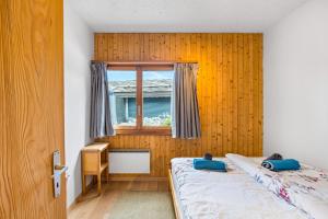 a bedroom with two beds and a window at Les 4 Abeilles - 6 pers - bien amenage in Nendaz