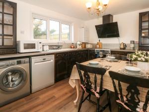 a kitchen with a table and a dishwasher at Argoed in Holywell