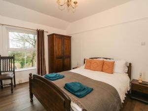a bedroom with a bed with two towels on it at Argoed in Holywell