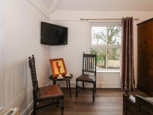 a living room with two chairs and a television at Argoed in Holywell