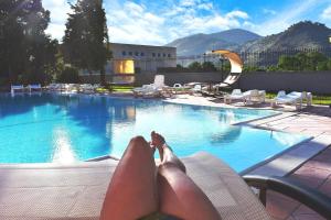 a person laying on a chair next to a swimming pool at IN BLOOM ROOM b&b in Castel San Giorgio
