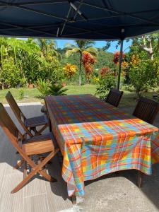 stół i krzesła pod parasolem na patio w obiekcie VILLA -Le Chalet Tropical w mieście Le Marin