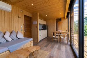 a bedroom with a bed and a table and a kitchen at Outscape Puyehue in Puyehue