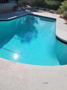 a swimming pool with blue water in a yard at Staycation near Flamingo road in Las Vegas