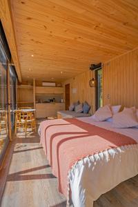een slaapkamer met 2 bedden in een houten kamer bij Outscape Puyehue in Puyehue