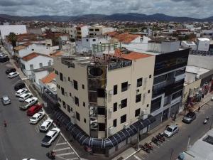 a large building with cars parked in a parking lot at Germano's Hotel in Jequié