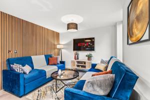 a living room with a blue couch and a table at Expansive Getaway in Cheltenham - Sleeps 15 in Cheltenham