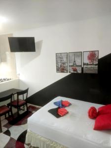 Schlafzimmer mit einem Bett mit roten Kissen und einem Tisch in der Unterkunft Apartamento próx do centro São Bernardo do Campo in São Bernardo do Campo