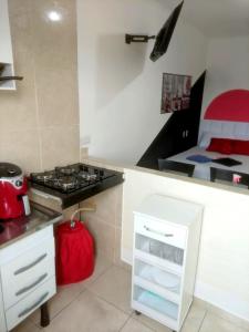 a small kitchen with a stove and a bed at Apartamento próx do centro São Bernardo do Campo in São Bernardo do Campo