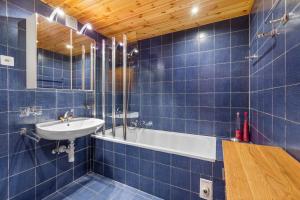 a blue tiled bathroom with a sink and a tub at Chaedoz 14-1 - 4 pers - au calme in Nendaz +28 photos
