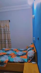 een slaapkamer met een bed met een kleurrijk dekbed bij Guest house AKPAKPA in Cotonou