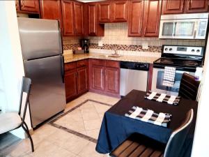a kitchen with a table and a stainless steel refrigerator at Staycation near Flamingo road in Las Vegas