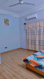 een kamer met een bed in een kamer met een gordijn bij Guest house AKPAKPA in Cotonou
