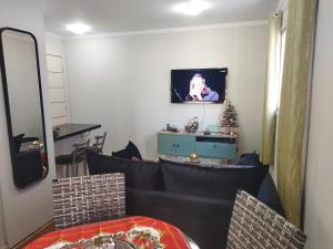 a living room with a couch and a tv on the wall at Century Hall in Curitiba