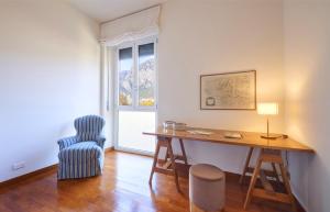 Zimmer mit einem Schreibtisch, einem Stuhl und einem Fenster in der Unterkunft Verde Acqua two Apartments in Lecco