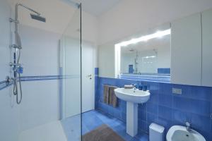 a blue bathroom with a sink and a shower at Verde Acqua two Apartments in Lecco