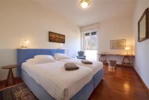 a bedroom with a large bed with a blue headboard at Verde Acqua two Apartments in Lecco