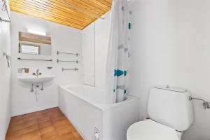 a white bathroom with a toilet and a sink at Chaedoz 55 - 6 pers - au calme in Nendaz +25 photos
