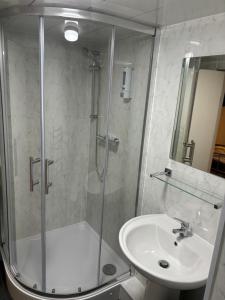 een badkamer met een douche en een wastafel bij Netherby Guest House in Edinburgh