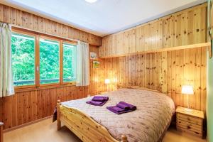 um quarto com uma cama com toalhas roxas em Chaedoz 45 - 7 pers - au calme em Nendaz