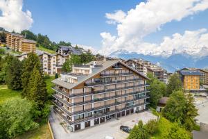 ein Apartmenthaus mit Bergen im Hintergrund in der Unterkunft Panoramic E6 - 4 pers - pres des pistes in Nendaz