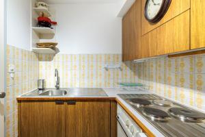 eine Küche mit Spüle und einer Uhr an der Wand in der Unterkunft Panoramic E6 - 4 pers - pres des pistes in Nendaz