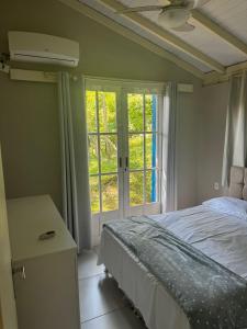 Schlafzimmer mit einem Bett und einem Fenster in der Unterkunft Villa Cabanas - Pé na areia in Governador Celso Ramos