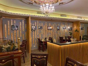 a restaurant with tables and chairs and a chandelier at Hotel & Restaurant Com Viet in Oschatz