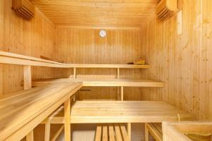 a wooden sauna with wooden shelves and a clock at Eden Roc 6 - 4 pers - pres des pistes in Nendaz +1 photo