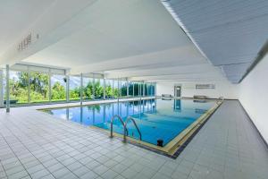 a large swimming pool with blue water in a building at Quille du Diable 46 - 4 pers - piscine in Nendaz +20 photos