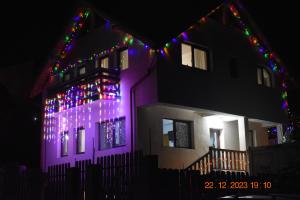 a house with christmas lights on the side of it at Capra cu trei iezi in Sinaia