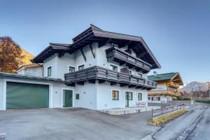 una casa blanca con techo de gambrel en Apartment Wilder Kaiser en Kitzbühel