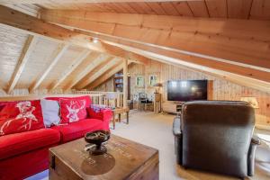 a living room with a red couch and a tv at Gisele - 8 pers - pres des pistes in Nendaz