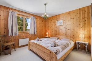 - une chambre avec un grand lit dans un mur en bois dans l'établissement Gisele - 8 pers - pres des pistes, à Nendaz