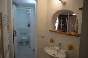 a bathroom with a sink and a mirror and a toilet at Villa Janas in San Teodoro