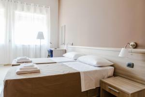 um quarto com 2 camas e toalhas em B&B SALento em San Cesario di Lecce