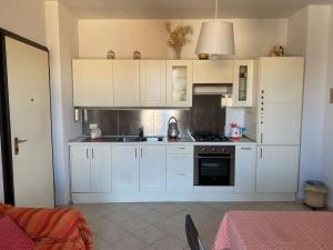 a kitchen with white cabinets and a stove at Bright apt with views and terrace in Florence +12 photos
