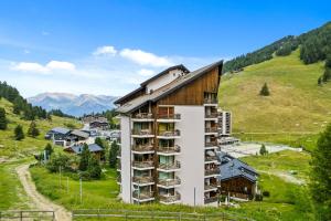 un edificio con balcones al lado de una colina en Mont-Fort 12 - 4 pers - au pied des pistes, en Noveli