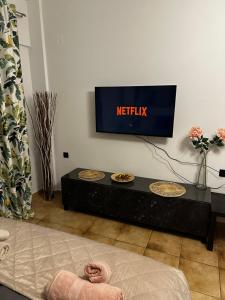 a television in a living room with plates on a table at Νεάπολη in Larisa